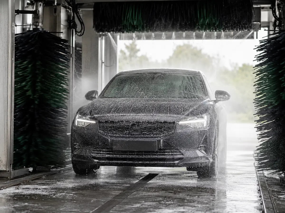 Car being washed with foam and a pressure hose